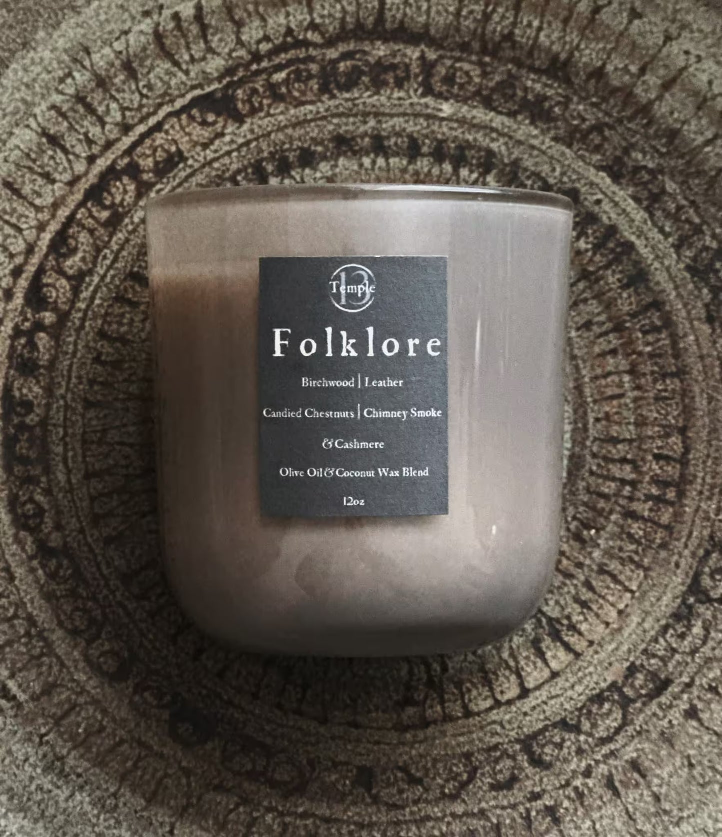 Candle with a label on a textured surface
