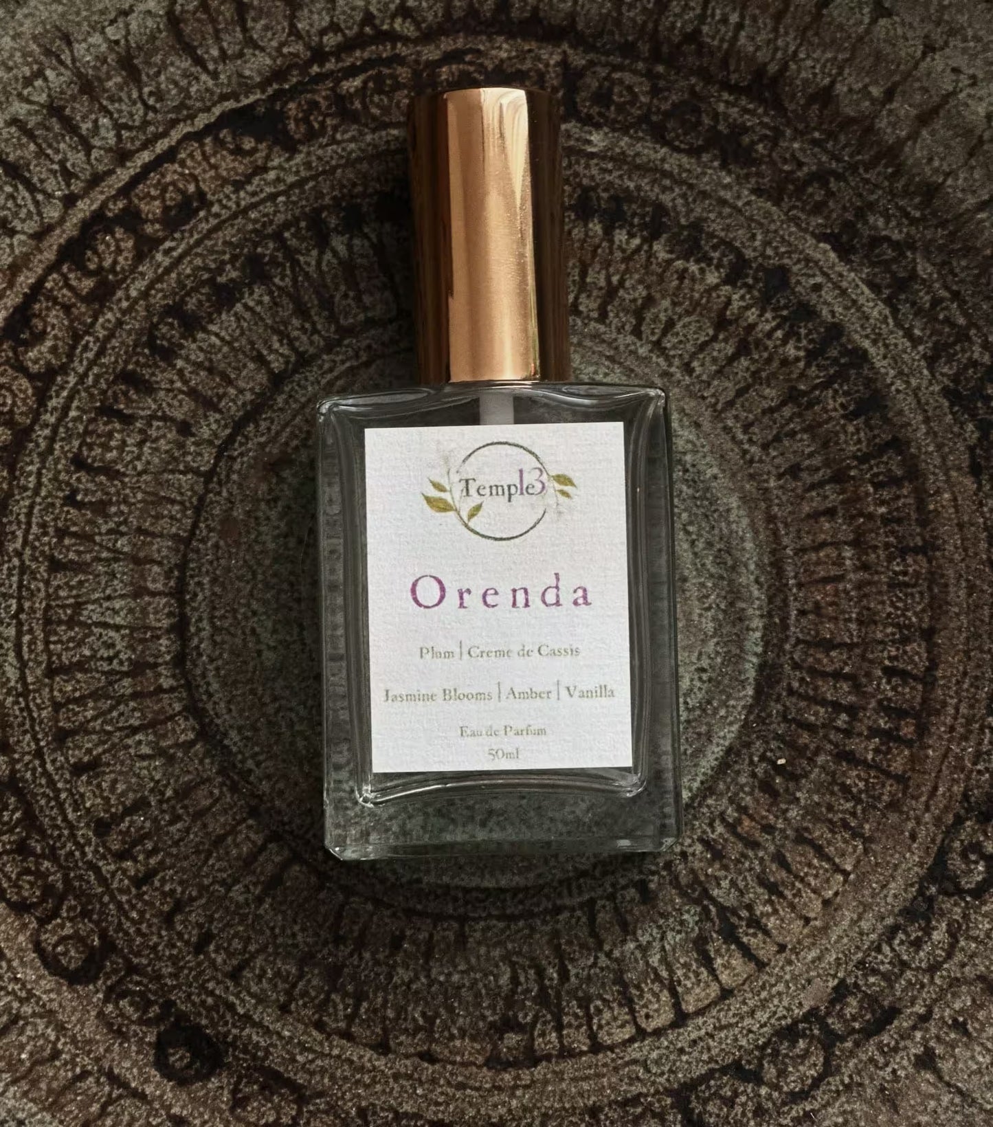 Perfume bottle labeled 'Orenda' on a textured surface