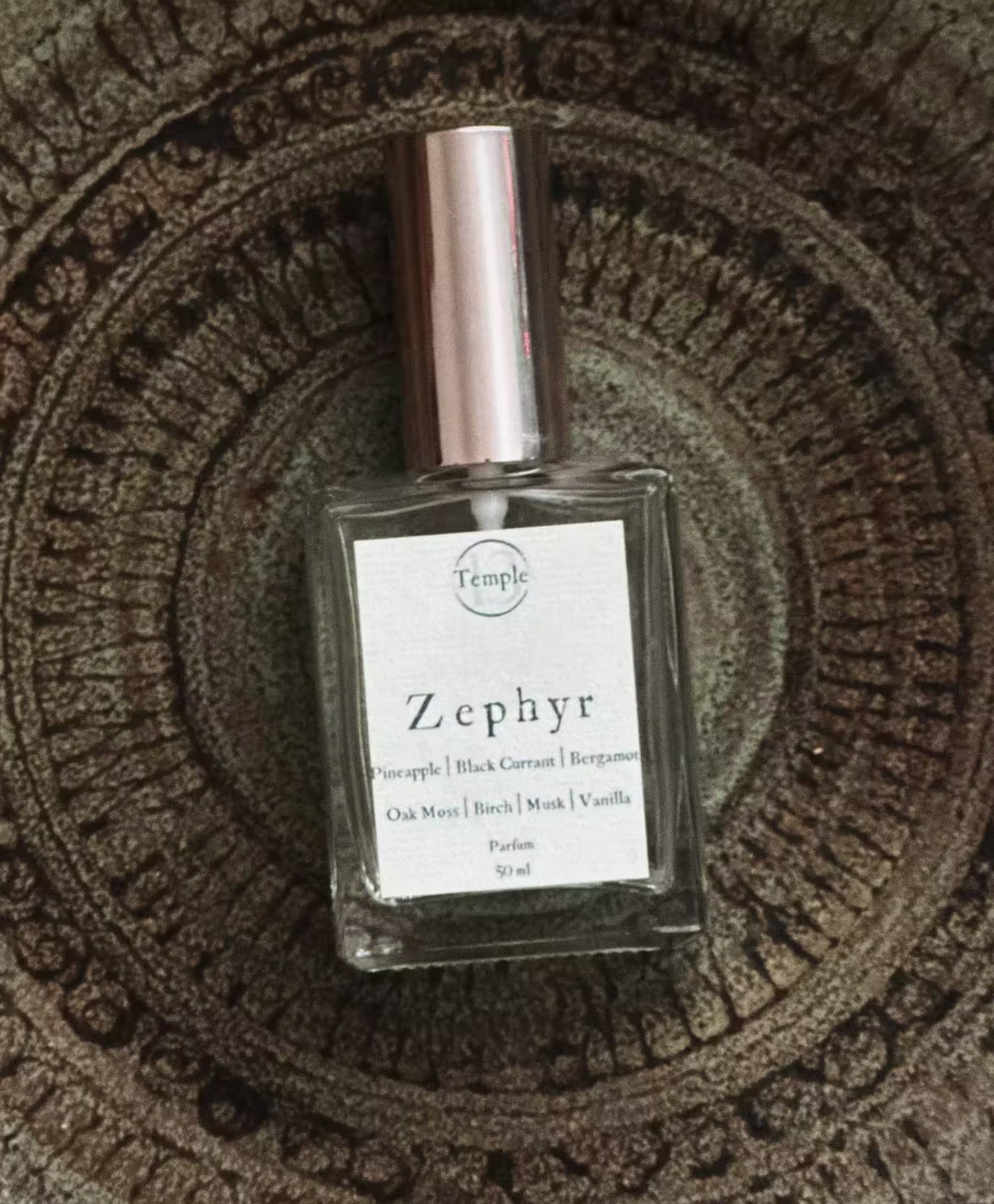 Perfume bottle labeled 'Zephyr' on a textured surface