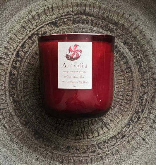 Red candle labeled 'Arcadia' on a textured surface