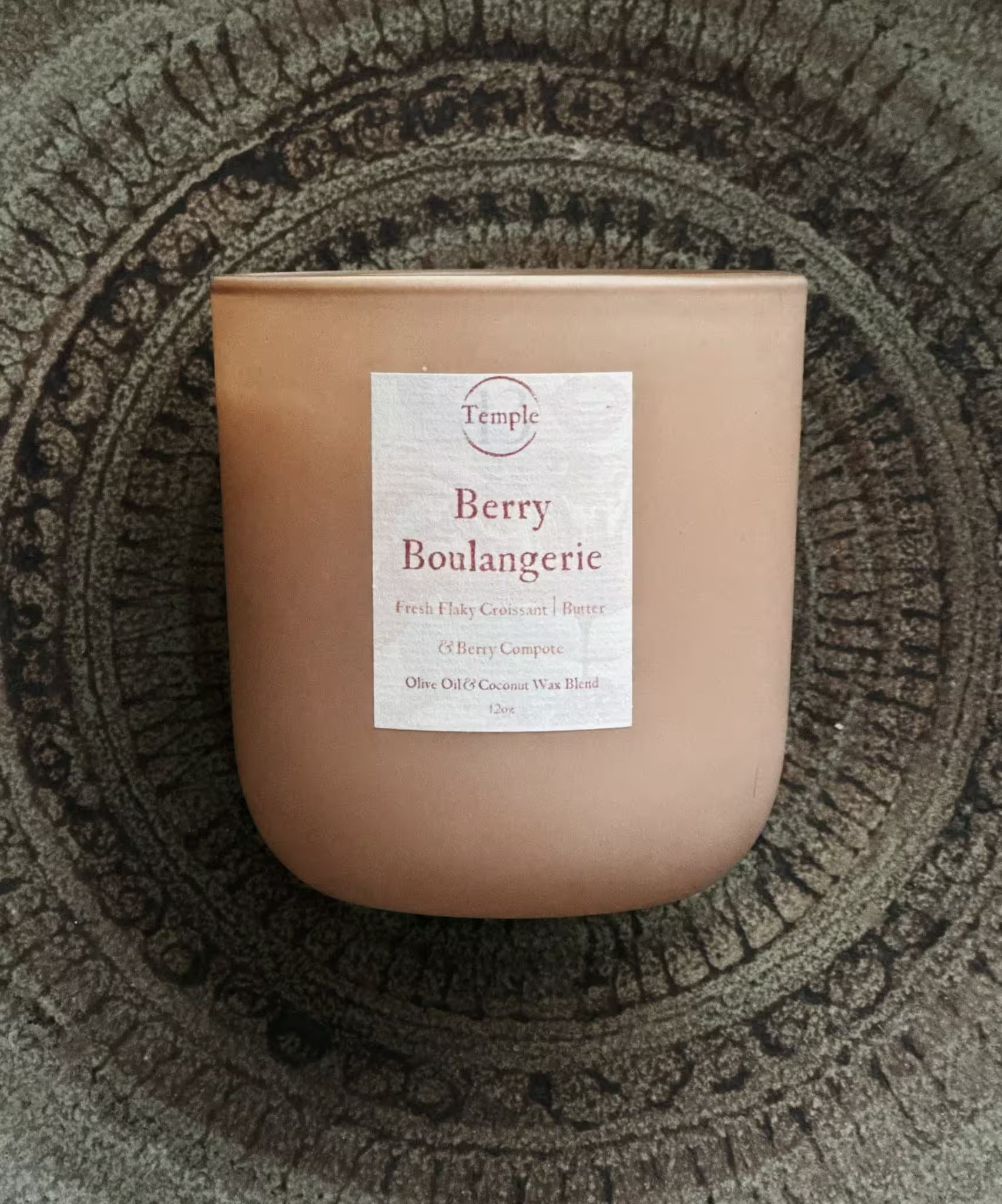 Candle with a label on a textured surface