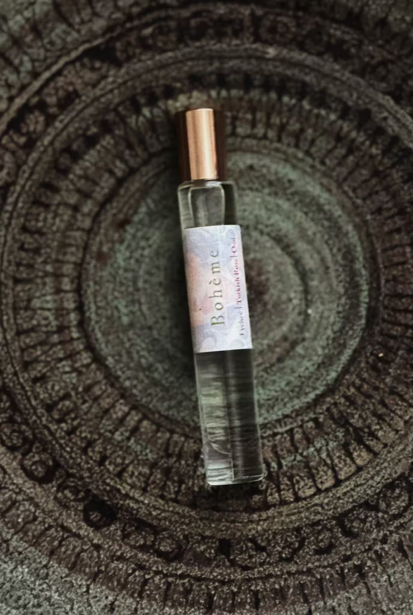 Small perfume bottle with a label on a textured surface