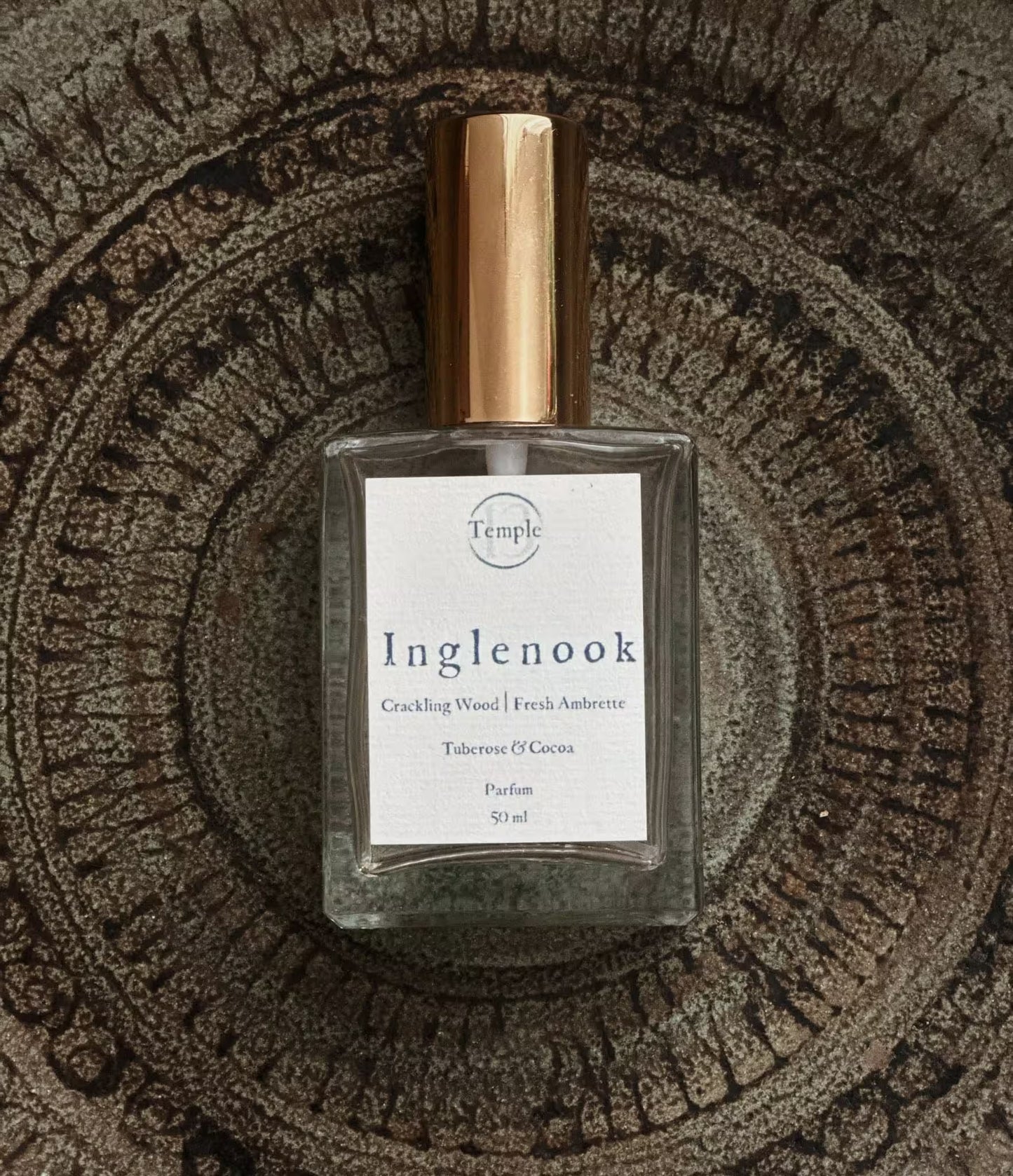 Perfume bottle labeled 'Inglenook' on a textured surface