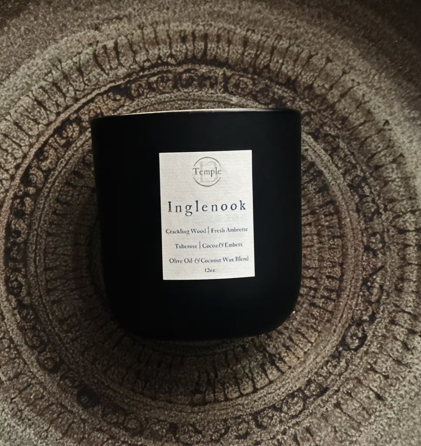 Black candle with a label on a textured surface