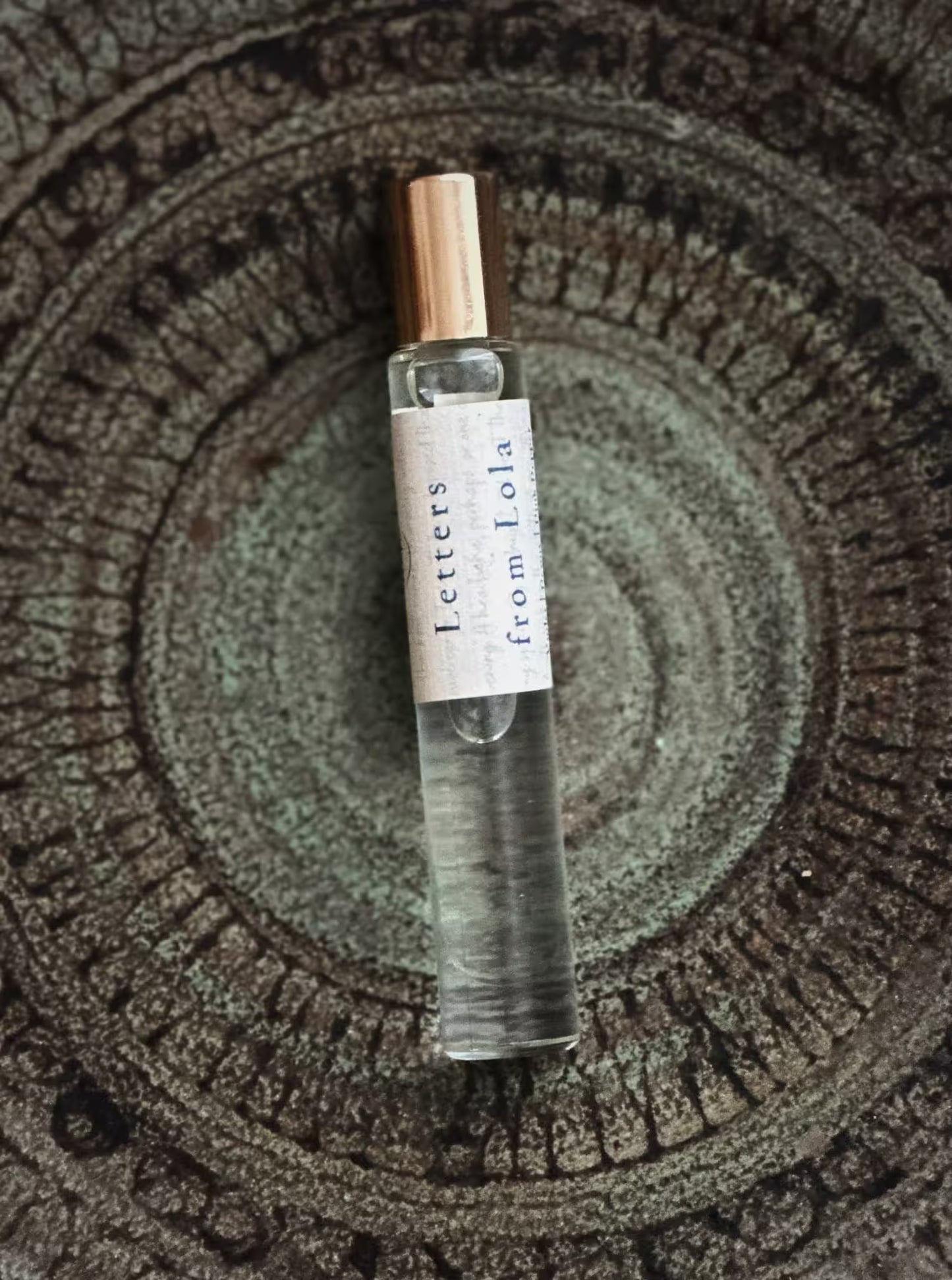Small perfume bottle labeled 'Letters from Lola' on a textured surface