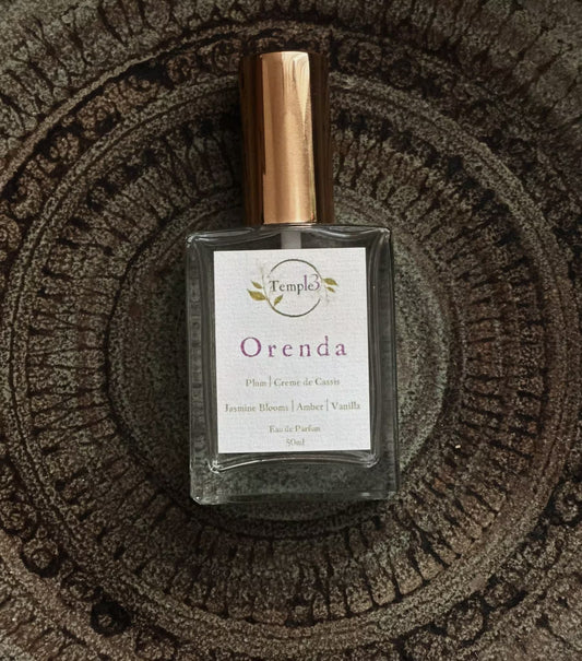Perfume bottle labeled 'Orenda' on a textured surface