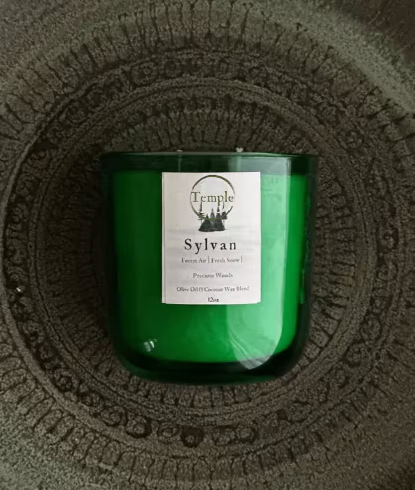 Green candle with a label on a textured surface