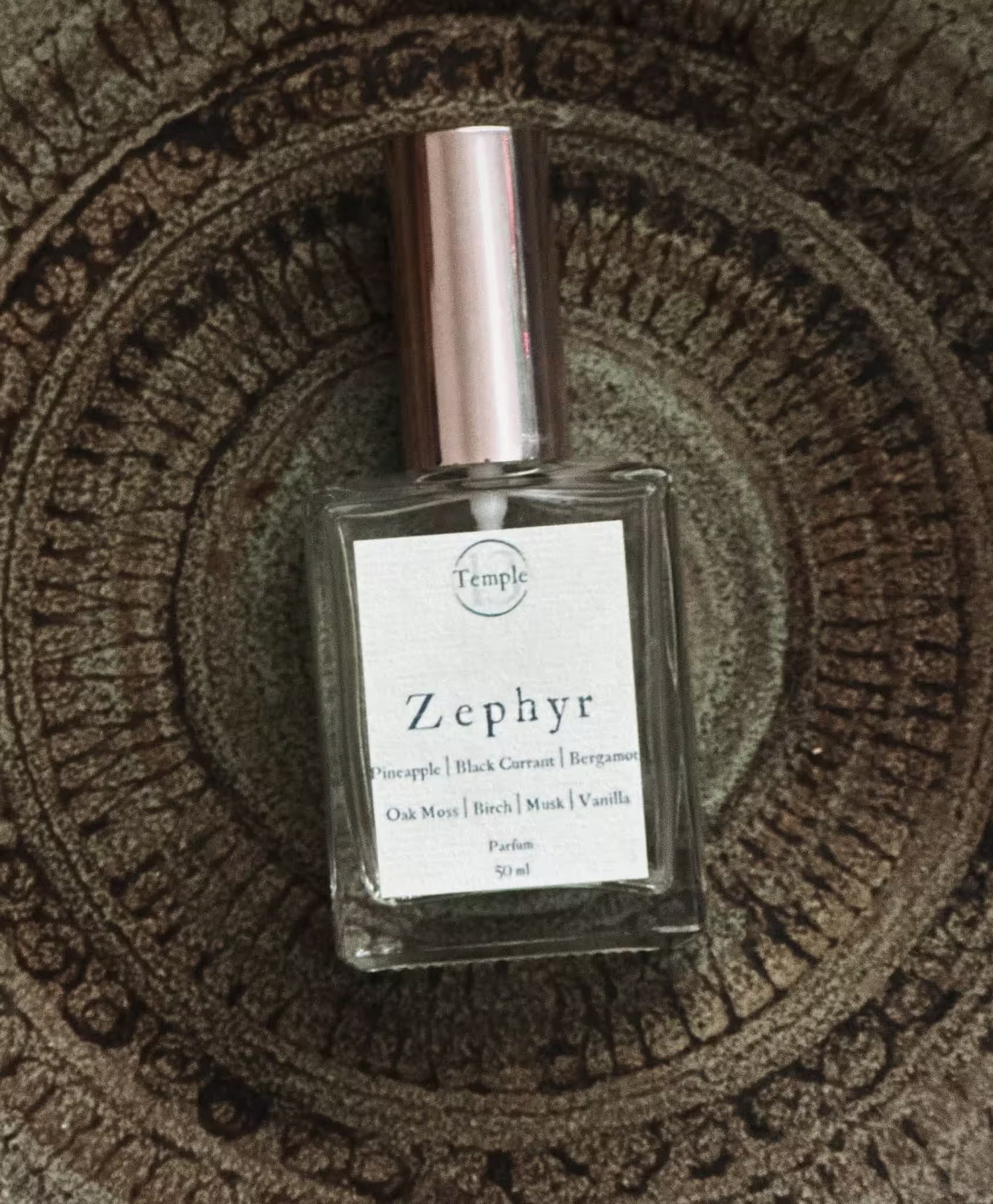 Perfume bottle labeled 'Zephyr' on a textured surface